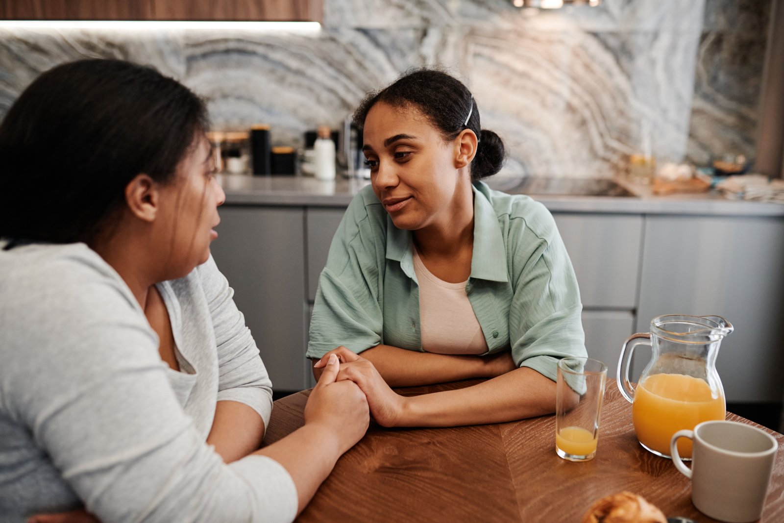 Duas mulheres conversando com atenção em torno de uma mesa