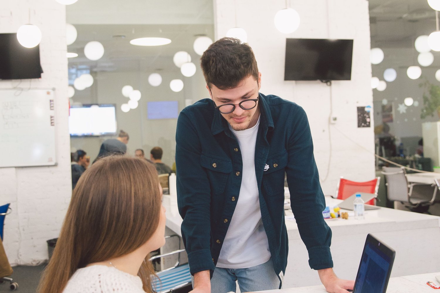 Duas pessoas conversando sobre um projeto em um espaço de trabalho